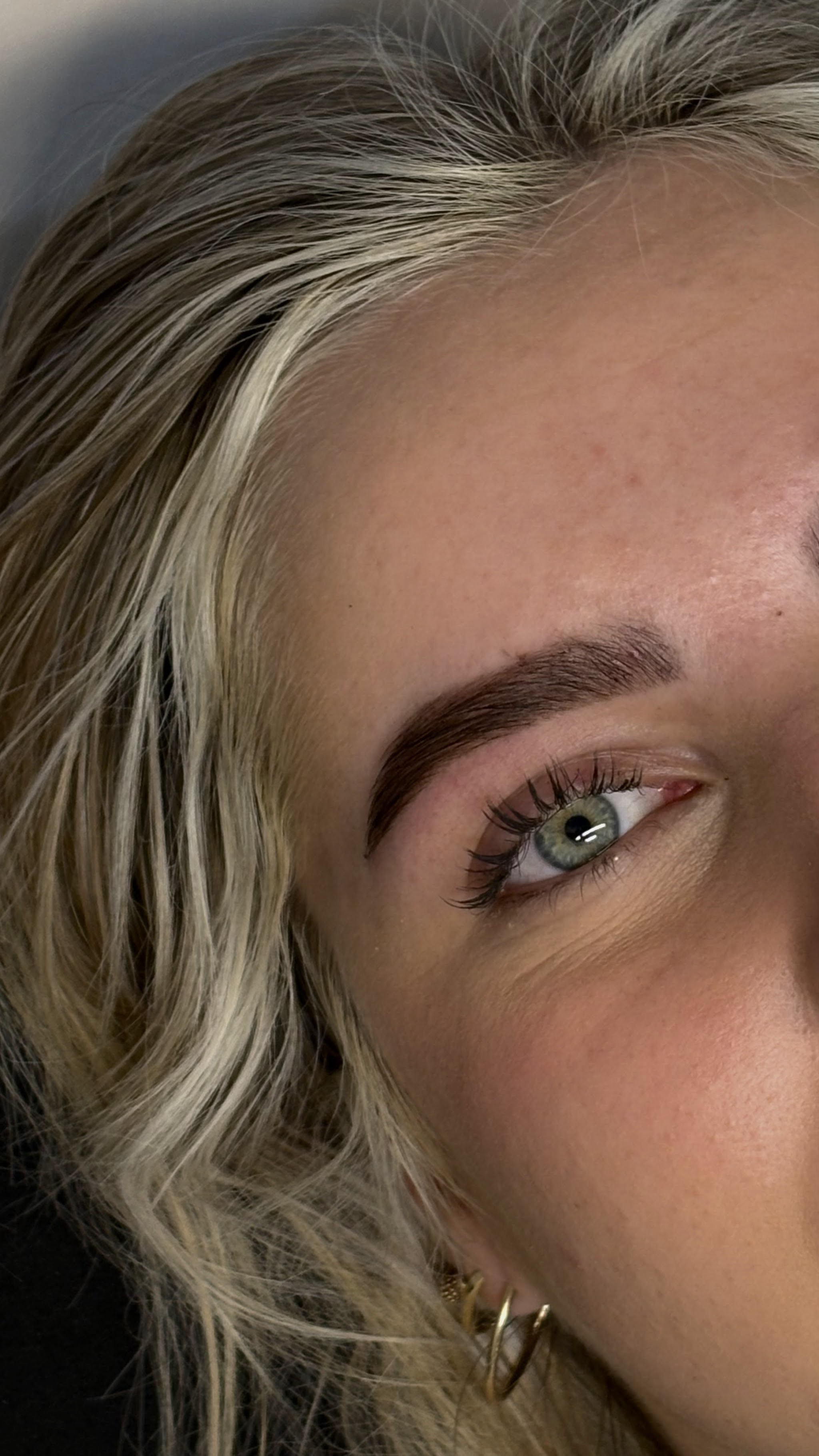 Zijaanzicht van een gelamineerde wenkbrauw en lash extensions