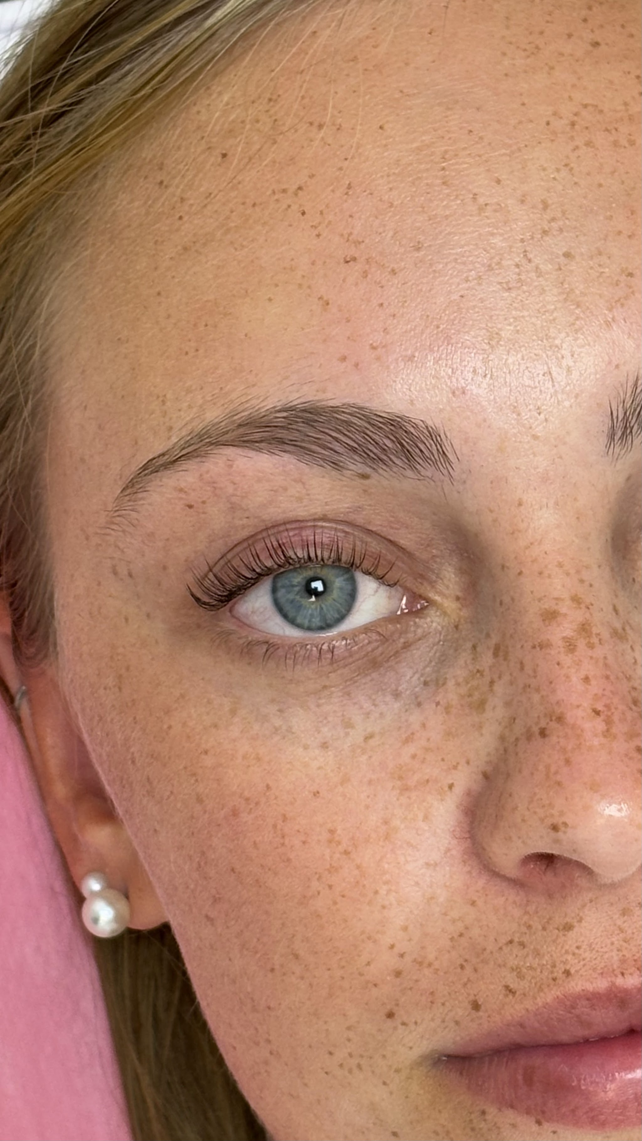 Close-up van een oog met gelifte wimpers en verzorgde wenkbrauw
